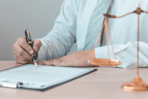Man in tie signs document with black and gold pen