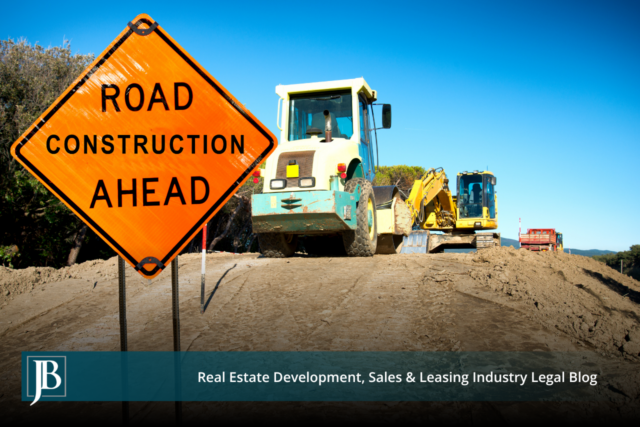 Orange "Road Construction Ahead" sign beside a roller and excavator grading a dirt roadbed, illustrating Florida's Turnpike Widening construction in Central Florida.