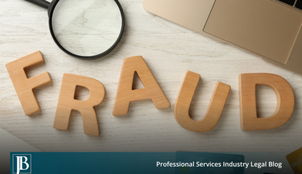 Wooden block letters spelling the word FRAUD on a white desk next to a magnifying glass, a laptop, and a credit card, illustrating an investigation into fraud allegations in Florida commercial litigation.