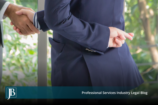 Business partner in a suit shaking hands while crossing his fingers behind his back, symbolizing a partner who breached their fiduciary duty.