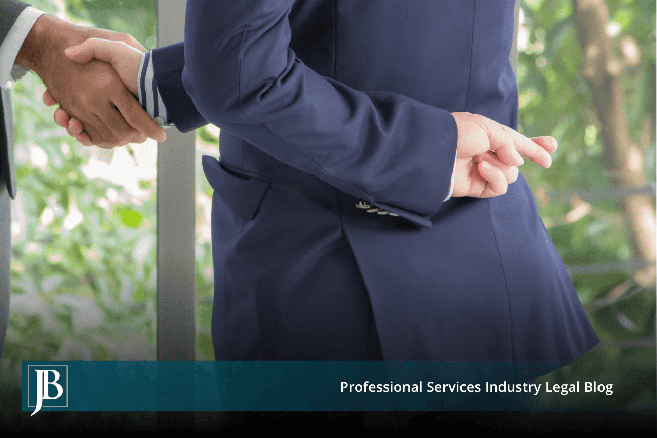 Business partner in a suit shaking hands while crossing his fingers behind his back, symbolizing a partner who breached their fiduciary duty.