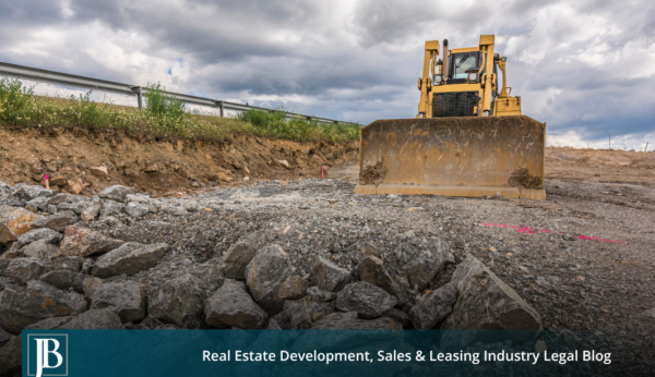 Bulldozer clearing rock and shoulder along a Florida highway guardrail during a Palmetto Expressway (SR 826) expansion style road construction project.