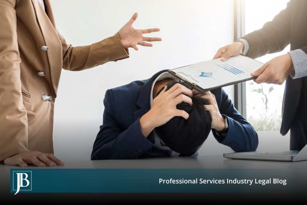Minority business owner slumped over a conference table with his head in his hands while two majority owners hand him a financial report, illustrating a shareholder freeze-out dispute.