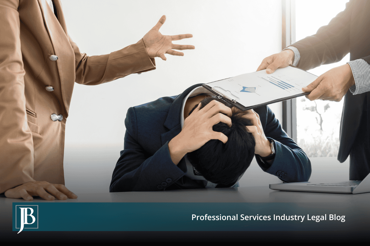 Minority business owner slumped over a conference table with his head in his hands while two majority owners hand him a financial report, illustrating a shareholder freeze-out dispute.