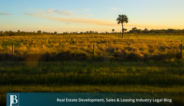 Sunset over open grassland, a wire fence, and a lone palm tree in the Everglades Agricultural Area near the EAA Reservoir site in western Palm Beach County, Florida.