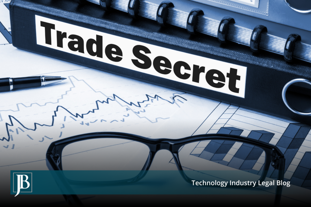 Black binder labeled "Trade Secret" resting on financial charts beside eyeglasses and a pen, illustrating trade secret misappropriation litigation in Florida.