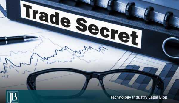 Black binder labeled "Trade Secret" resting on financial charts beside eyeglasses and a pen, illustrating trade secret misappropriation litigation in Florida.
