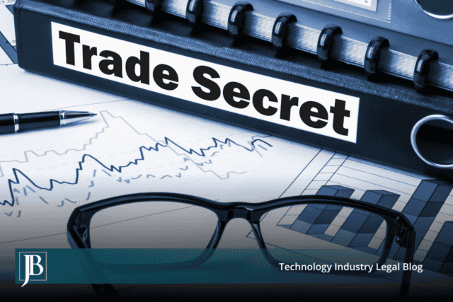 Black binder labeled "Trade Secret" resting on financial charts beside eyeglasses and a pen, illustrating trade secret misappropriation litigation in Florida.