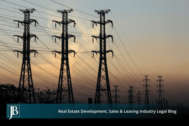 Silhouetted high-voltage electric transmission towers and power lines stretching across a Florida sky at sunset, illustrating a Duke Energy transmission line easement corridor.