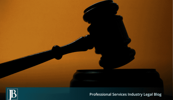 Silhouette of a judge's gavel resting on its sound block against a warm amber background, representing a court ruling on an emergency injunction.