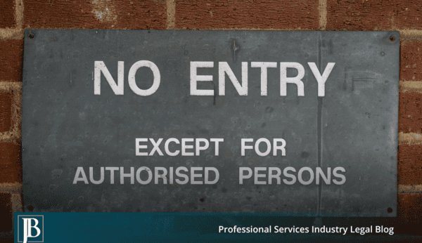 Weathered metal "No Entry Except For Authorised Persons" sign bolted to a red brick wall