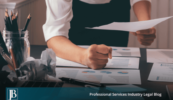 Business owner's clenched fist on printed financial charts, a warning sign a co-owner is mismanaging your company.