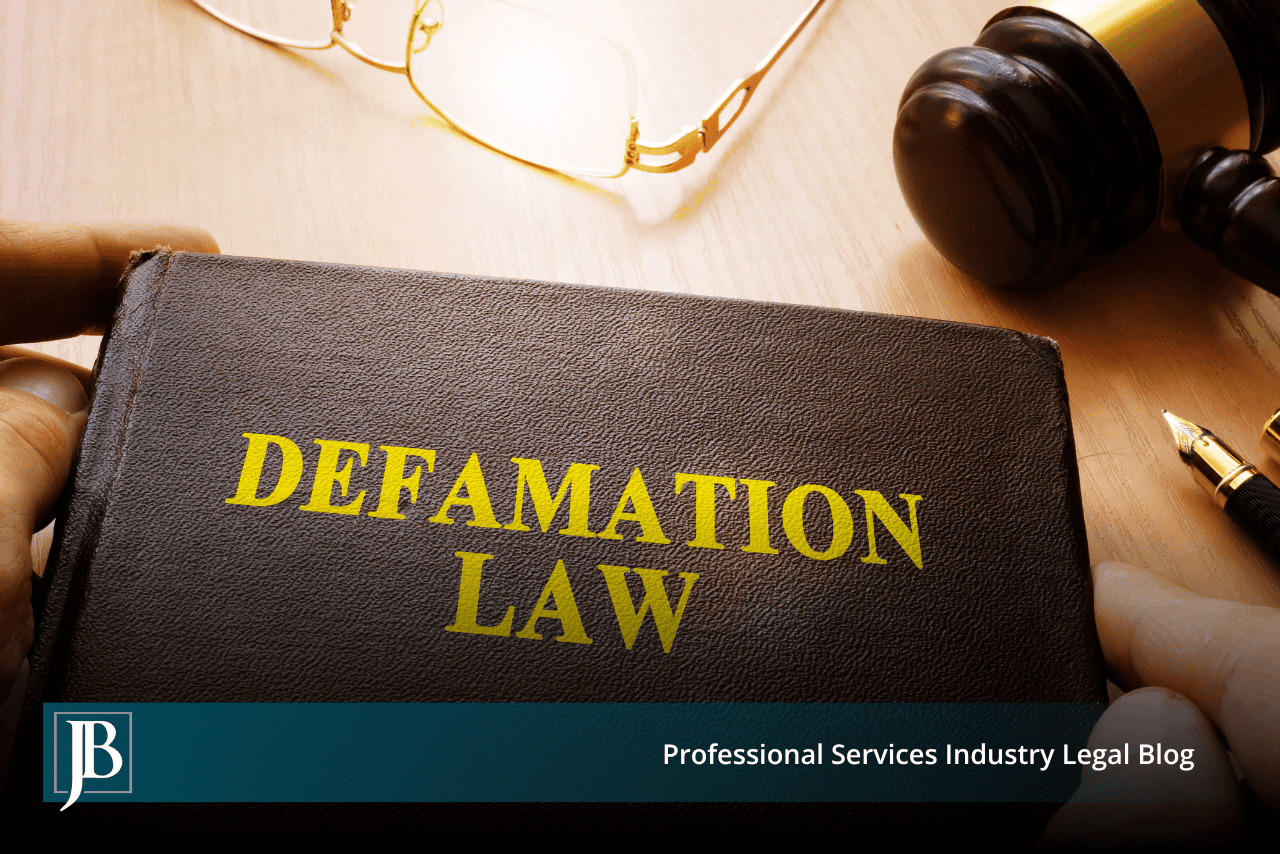 Hands holding a book titled Defamation Law beside a gavel and eyeglasses, illustrating business defamation claims in Florida