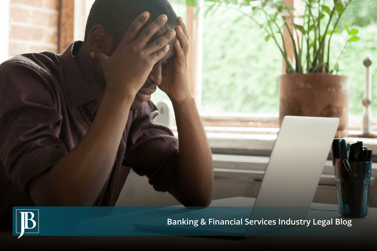 Man with his head in his hands at a laptop, illustrating an owner sued personally over a business debt in Florida