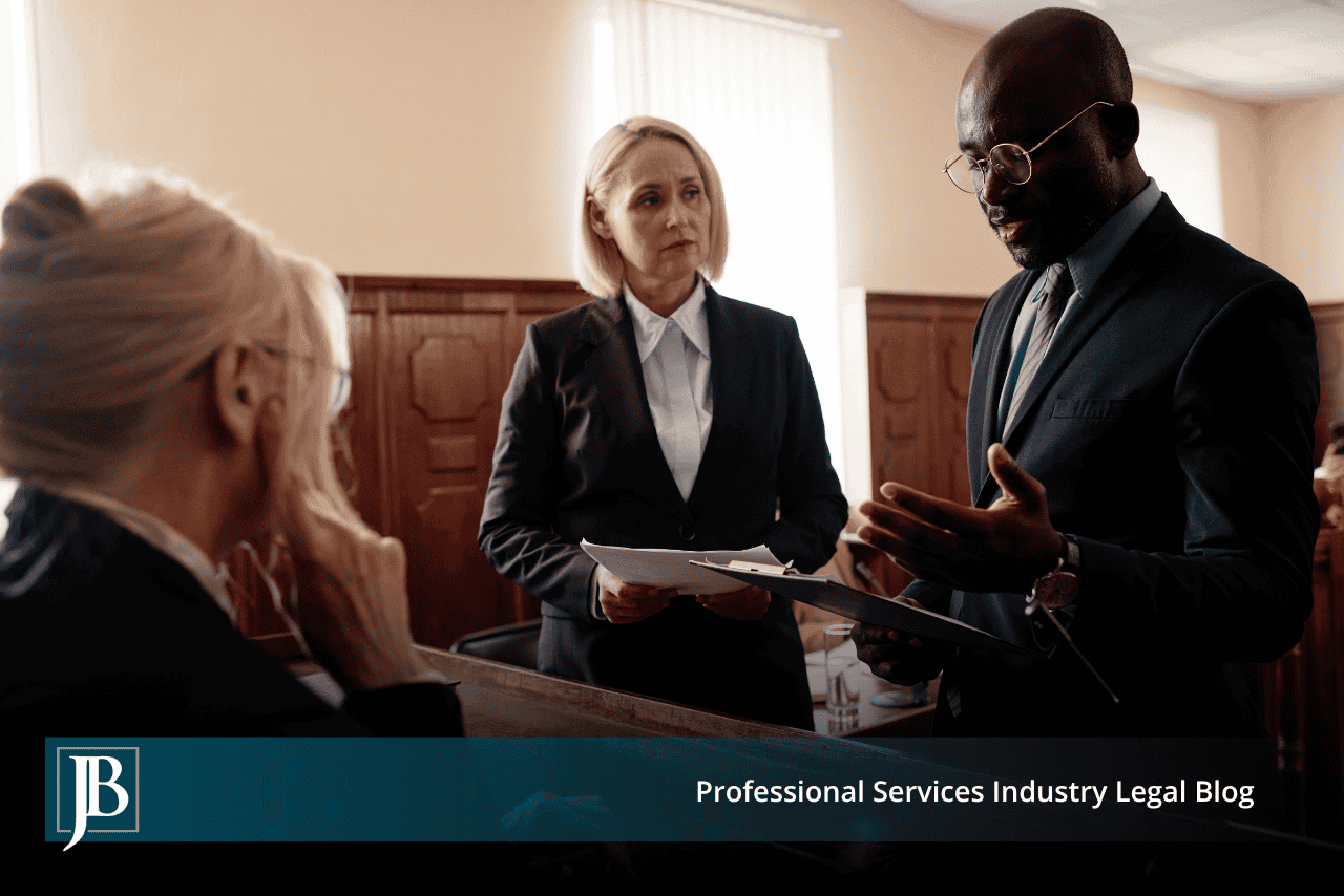 Professionals in dark suits confer over papers in a courtroom, illustrating malicious prosecution in Florida